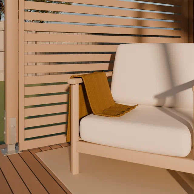 Close view of an outdoor armchair with a mustard throw, beside a slatted timber privacy screen on the deck.